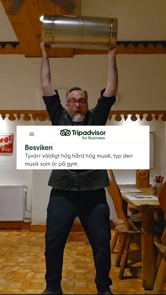 En man lyfter en metallbehållare över huvudet i matsalen, med en Tripadvisor-recension över bilden