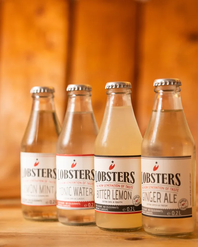 Fyra flaskor Lobsters läsk och tonic på ett träbord