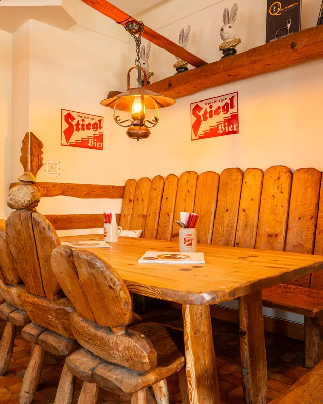 Handhuggen bänk och furubord under Stiegl-skyltarna