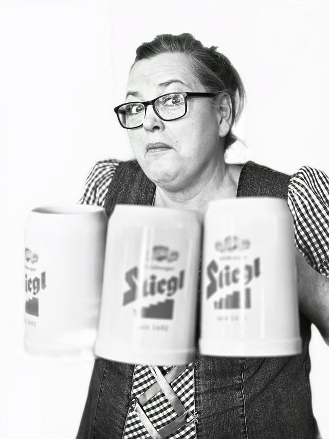 Kvinna i dirndl som håller fram tre Stiegl-sejdlar, svartvitt fotografi